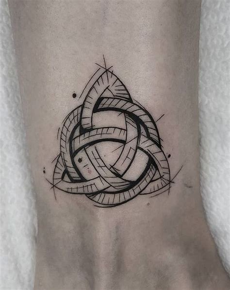 a black and white tattoo design on the ankle