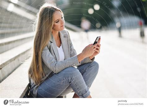 Blonde Woman Looking At Her Smartphone Outdoors A Royalty Free Stock Photo From Photocase