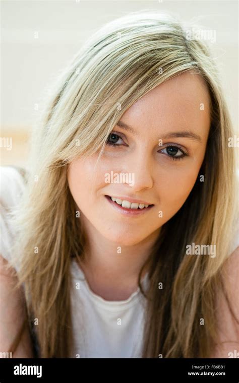 Head And Shoulder Shot Of Teenage Years Old Woman Facing With Eye Contact Long Blonde