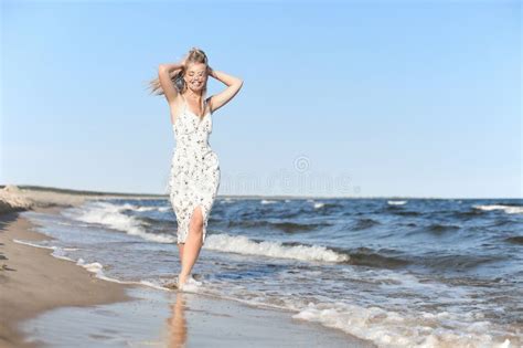 Happy Blonde Beautiful Woman Having Fun On Ocean Beach While Dancing In Waves Stock Image