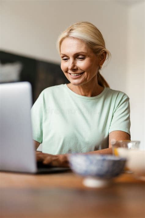 Blonde Mature Woman Working With Laptop While Having Lunch Stock Photo Image Of Work Laptop