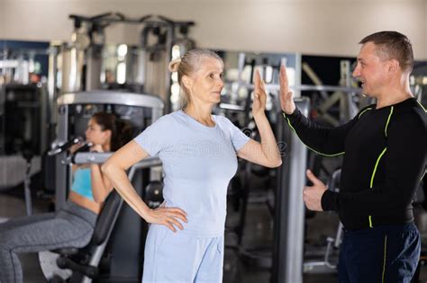 Happy Strong Male Fitness Trainer Talking To Mature Female Athlete Stock Image Image Of