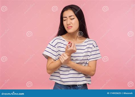 Wrist Sprain Portrait Of Girl With Brunette Hair Touching Injured Hand Grimacing In Pain