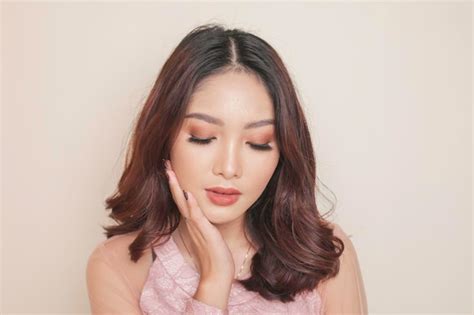 Rosto de beleza aproximado do jovem modelo asiático tocando a pele limpa maquiagem nude natural