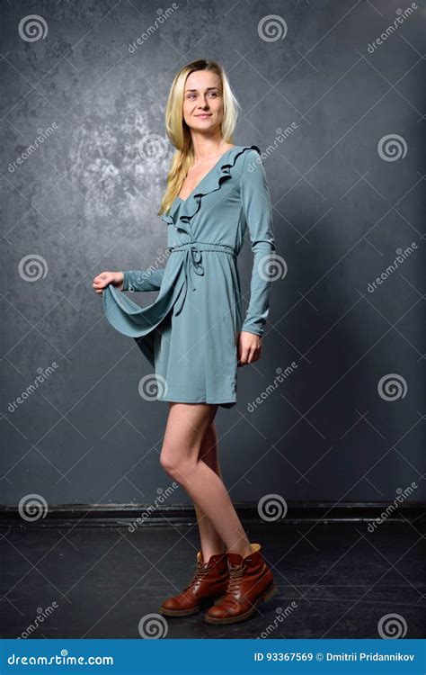 Skinny Blonde Girl In Gray Dress On The Background Of Gray Wall Stock Image Image Of Showing