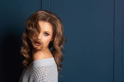 Premium Photo Sexy Blonde Woman With Curly Hair Wearing Sweater With Naked Shoulders Space