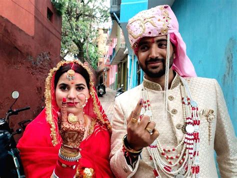 A Newly Wedded Couple Show Their Fingers Marked With Indelible Ink