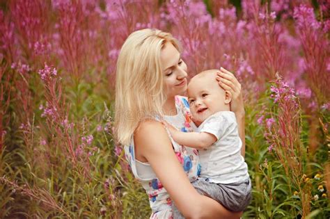 Blonde Hermoso En Una Madre Del Sombrero Que Besa A Su Hijo En La Puesta Del Sol En Th Foto De