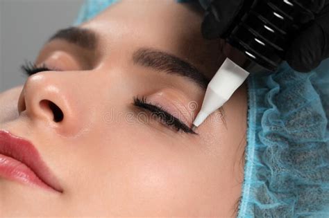 Young Woman Undergoing Procedure Of Permanent Eye Makeup Closeup Stock