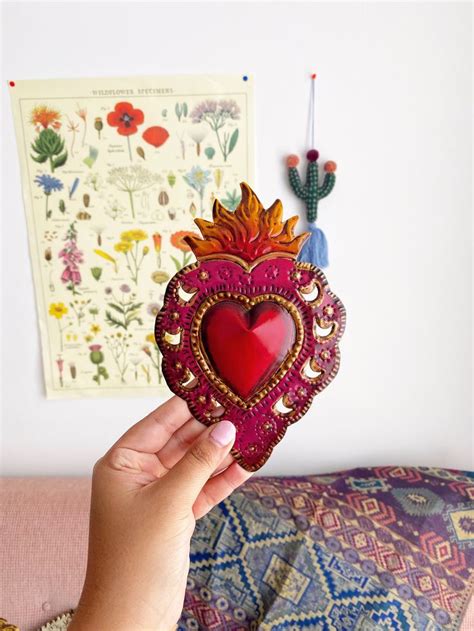 A Person Holding Up A Heart Shaped Decoration