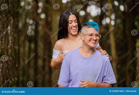 Happy Hispanic Lesbian Couple Hugging In A Forest Stock Photo Image Of Happy Lgbt