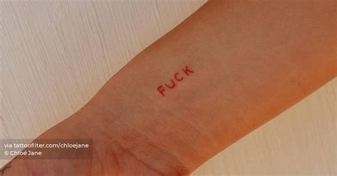 Fuck Lettering Tattoo In Red Ink Placed On The Wrist