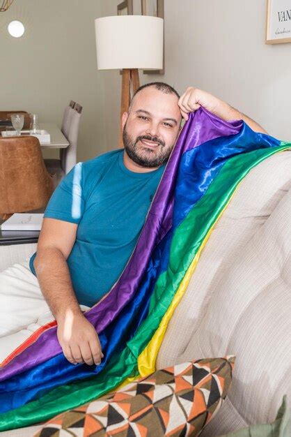 Hombre Gay Sentado En Un Sof En Casa Con Bandera Lgbt Foto Premium