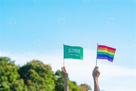 Hands Showing LGBTQ Rainbow And Saudi Arabia Flag On Nature Background Support Lesbian Gay