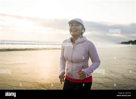 Fit And Attractive Mature Woman With Grey Hair Doing Beach Workout On Her S Running On The