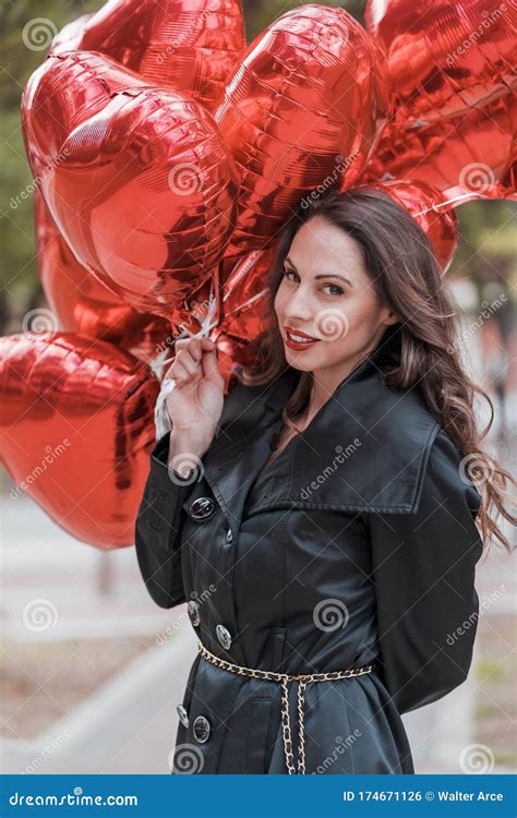 Lovely Hispanic Brunette Model Celebrates Valentines Day With A Dozen Red Heart Balloons Stock