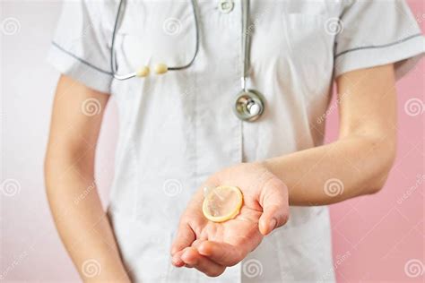 Female Doctor Holding Condom For Aids Prevention And Birth Control