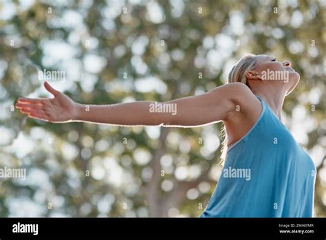 Greet The World With Peace Everyday A Mature And Fit Woman Standing Outside In Nature With Her