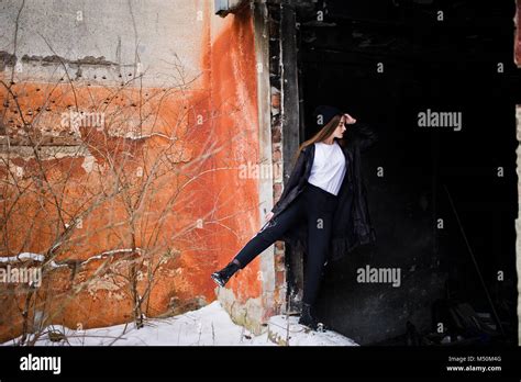 Fashionable Long Legs Brunette Model In Long Black Cloak Posed Outdoor At Winter Day Against Old