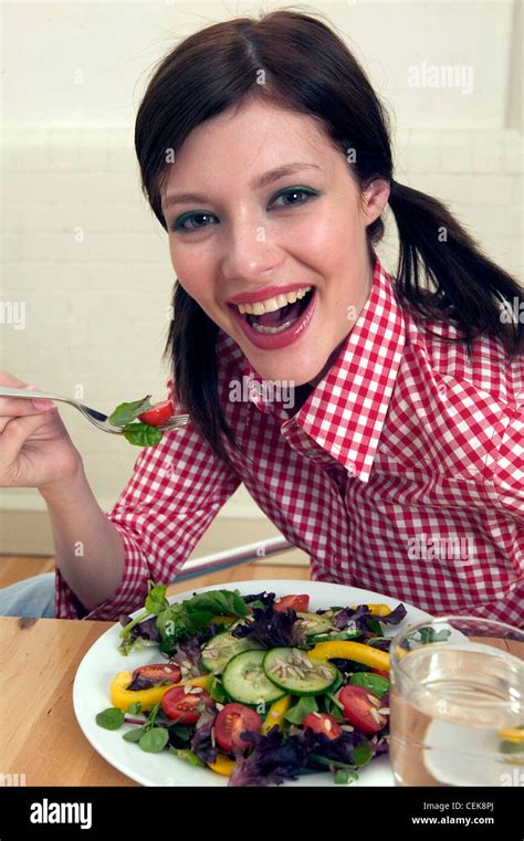 Female Brunette Hair Off Face Wearing Red And White Checked Shirt Holding Fork Half Cherry