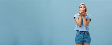 Une photo en studio d une jolie et romantique petite amie blonde européenne en short en jean qui