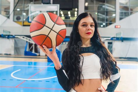 Brunette Cheerleader In Black And White Uniform With A Jacket Posing