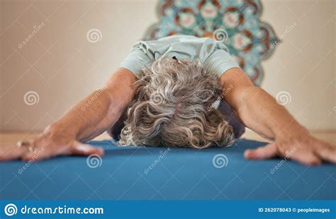 Elderly Yogi Man With Naked Torso In Brown Pants Is Practicing Yoga Standing On His Hands