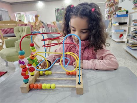 Year Old Latina Girl With Curly Hair Plays An Educational Game Like A Wooden Maze For