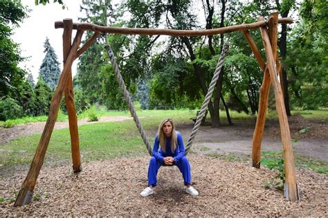 Jolie Femme Blonde Assise Sur Une Balan Oire Suspendue Un Arbre Dans Un Costume Bleu Dans Le