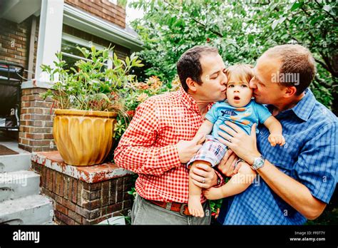 Gay Fathers Kissing Baby Son Outdoors Stock Photo Alamy