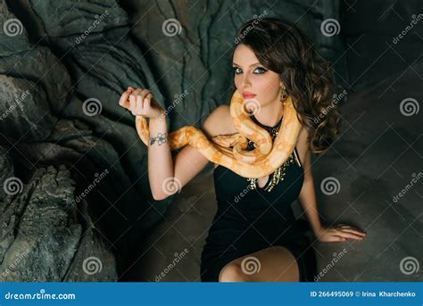 Beautiful Cute Charming Woman Sits On Gray Stone Natural Cave Brunette Girl With Long Wavy Hair