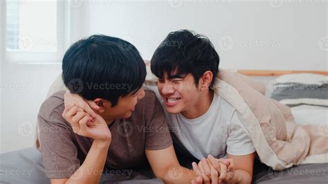 Guapo pareja gay asiática hablando en la cama en su casa joven asiático lgbtq feliz relajarse