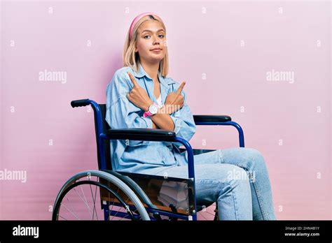 Belle Femme Blonde Assise Sur Un Fauteuil Roulant Pointant Des Deux C T S Avec Les Doigts
