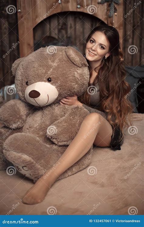 Pretty Cute Brunette Girl Posing With Big Teddy Bear On The Floor In Cozy Comfortable Interior