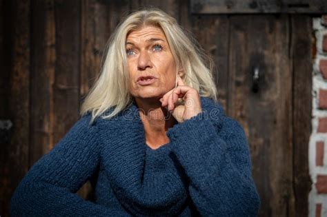 Blonde Woman In Her Mid Fifties Wearing A Wide Blue Knitted Sweater Stock Image Image Of