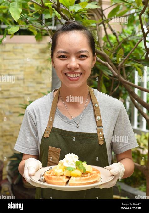 Vietnamese Woman Waitress Serving Belgian Waffles With Fruits And Ice