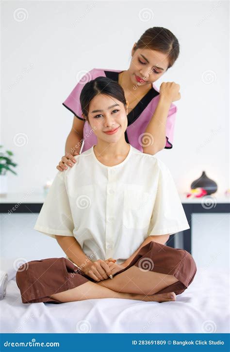 Portrait Shot Of Millennial Asian Female Relaxed Customer Sitting On Massage Bed While