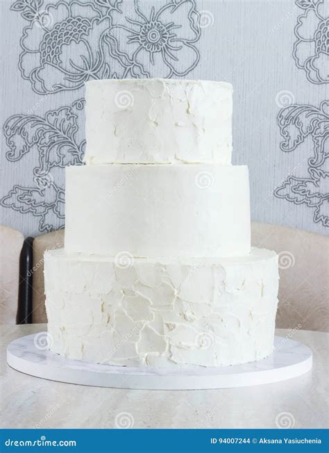 Naked Three Tiered Cake Without Ornaments On The Table Stock Photo