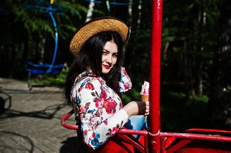Free Photo Portrait Of Brunette Girl In Pink Glasses And Hat With Ice Cream At Amusement Park