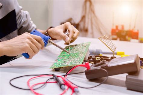 close    hand men hold tool repairs electronics manufacturing