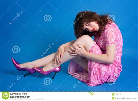 Jonge Brunette In Een Roze Kleding Op Een Blauwe Achtergrond Stock Afbeelding Image Of Vloer