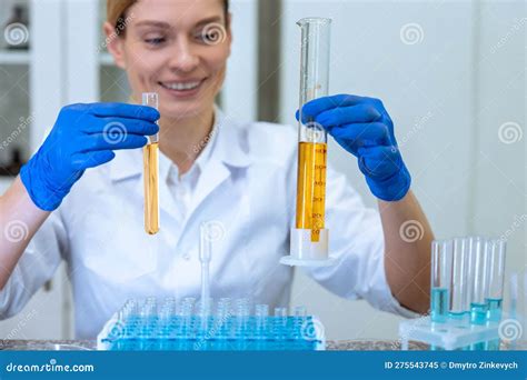 Biologo Donna In Possesso Di Tubi Di Prova Con Liquido Giallo A Mani Nude Che Fanno Esperimenti