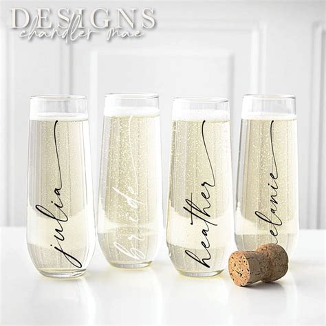 Three Wine Glasses With The Word Champagne Written In Cursive Writing Next To A Cork