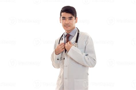 Jeune brunette médecin en uniforme bleu avec stéthoscope sur son cou isolé sur fond blanc