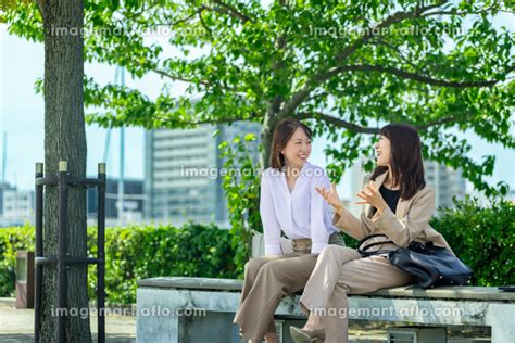 ベンチに座って話す2人の日本人ビジネスウーマン （女性 人物）の写真素材 [227778422] イメージマート