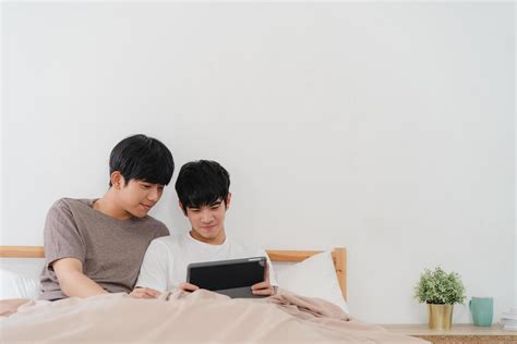 jeune couple gay asiatique utilisant une tablette à la maison 1227352 Photo de stock chez Vecteezy