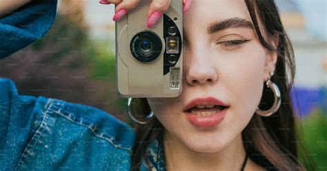 A woman taking a picture with a camera photo – 90s Image on Unsplash