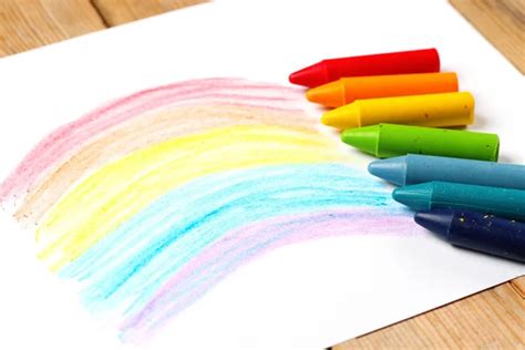 Oil Pastel Crayons Lying On A Paper With Painted Rainbow Stock Photo