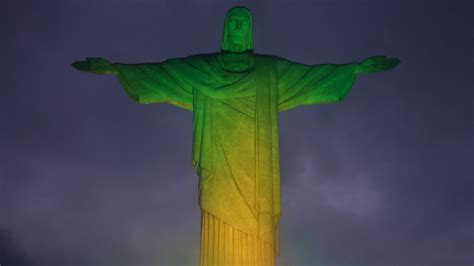 Em verde e amarelo Cristo Redentor é iluminado para estreia do Brasil