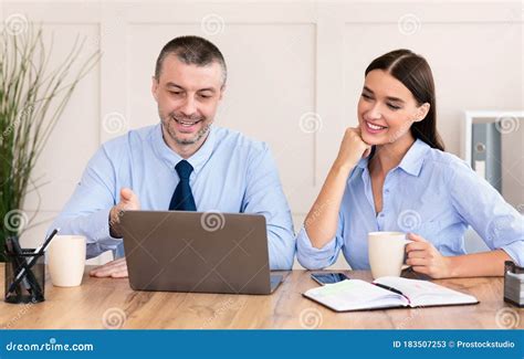 Cheerful Business Man And Woman At Laptop Working In Office Stock Image